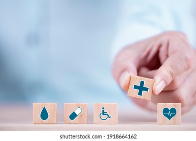 Businessman Chooses A Emoticon Icons Healthcare Medical Symbol On Wooden Block , Healthcare And Medical Insurance Concept