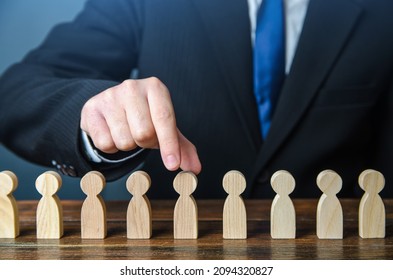 A businessman chooses a person from a row. Recruiting. Headhunter HR. Study and selection of candidates. Find the right candidate for the job. Management and Recruitment. Hire new workers - Shutterstock ID 2094320827