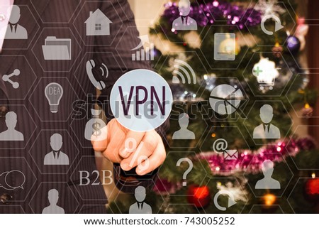 The businessman chooses a VPN on the touch screen, the backdrop of the Christmas tree and decorations