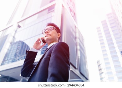 Businessman in city holding his mobile - Shutterstock ID 294434834