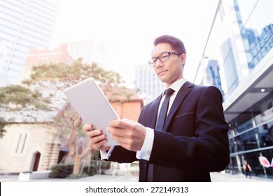 Businessman in city holding his notebook - Shutterstock ID 272149313