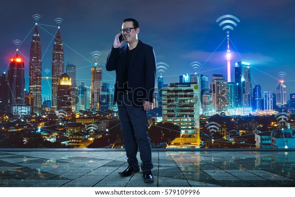 Businessman with city\
and wireless communication network background, abstract image\
visual, internet of\
things