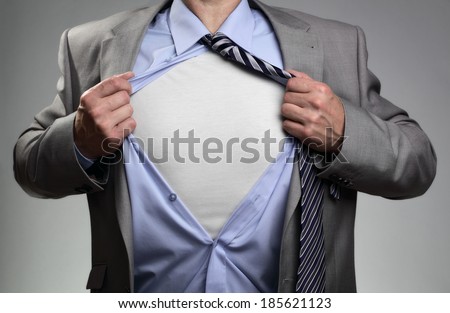 Businessman in classic superman pose tearing his shirt open to reveal t shirt with blank chest for message [[stock_photo]] © 
