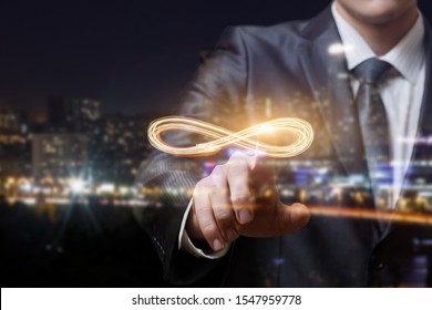 The businessman clicks the infinity sign on blurred background.