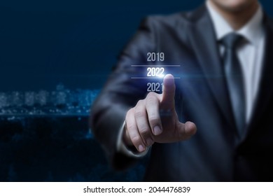 Businessman clik the coming 2022 on a blurred background. - Shutterstock ID 2044476839
