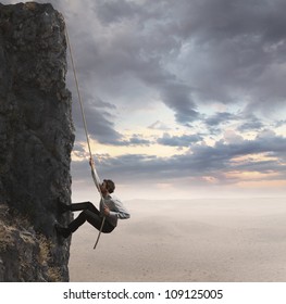 Businessman climbs the mountain. Concept of professional success