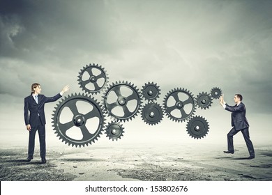 Businessman With Cog Wheel Elements. Construction Concept