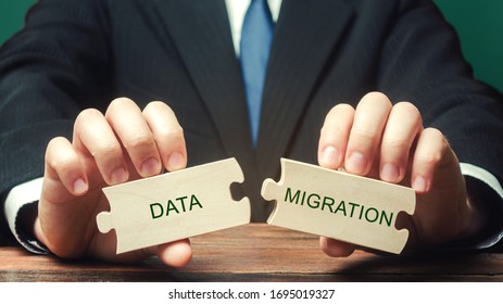 Businessman Collects Wooden Puzzles With The Words Data Migration. Process Of Preparing, Selecting, Extracting Data And Transferring From One Computer Storage System To Another.