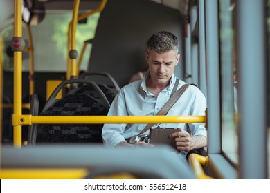 Businessman commuting to work by bus and working with a digital touch screen tablet - Powered by Shutterstock