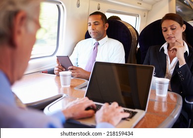 Businessman Commuting To Work On Train And Using Laptop