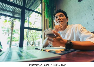 Businessman Company Owner Sitting Alone At Office Desk View Information By Mobile Phone Solves Business Questions Looking At Computer Screen Having Busy Effective Workday