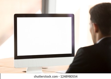 Businessman Company Worker In Office Working Using Computer With White Mockup Blank Screen. Empty Copy Space On Monitor For Business Advertisement Or Corporate Website Close Up View Over Man Shoulder