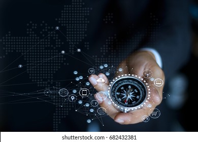 Businessman with a compass holding in hand. Define marketing direction and  search customer global network

