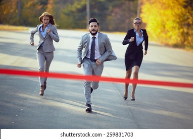 Businessman competing with two businesswomen