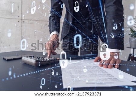 A businessman computing probability of risks in cyber security protection using calculator. Padlock Hologram icons over the working desk. Formal wear.