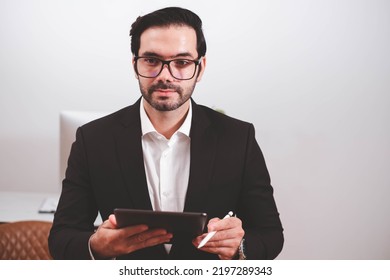 Businessman, Confident Male executive commuter is looking at hand held digital tablet screen. Confident professional making successful plan while working on laptop at office. - Powered by Shutterstock