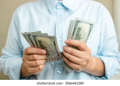 Businessman Considers American Dollar Bills Money To Pay Bills, Loans And Services. Wealth, Overhead. Transaction, Payment, Salary And Banking Concept.