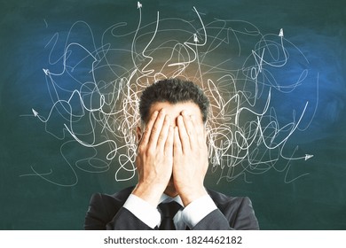 Businessman covered his face with his hands and  drawing  arrows on concrete wall. Leadership and way concept. Close up - Shutterstock ID 1824462182