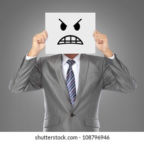 businessman covering his face with angry mask on gray background - Powered by Shutterstock