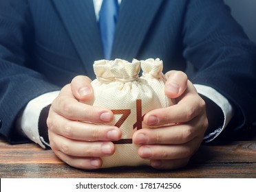 Businessman covers with hands polish zloty money bags. Corrupt schemes. Profit collection and tax withholding. Accumulation of funds, bank loan. Investments. Hit jackpot. Capital. Budget absorption - Shutterstock ID 1781742506