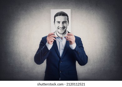 Businessman covers his head with a face print, like a fake mask for hiding real emotions. Sheet with positive face expression. Introvert person, anonymous hidden identity