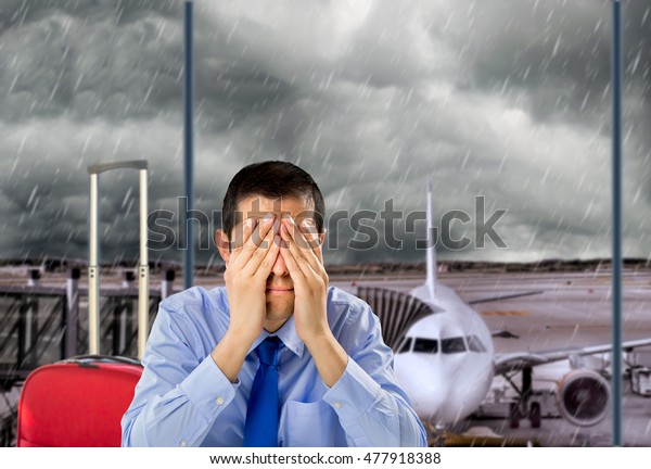 businessman crying by delayed flight because the\
stormy weather at the lobby\
airport