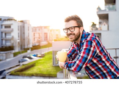 Businessman with cup of coffee standing on balcony, relaxing