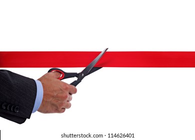 Businessman Cutting A Red Ribbon With A Pair Of Scissors