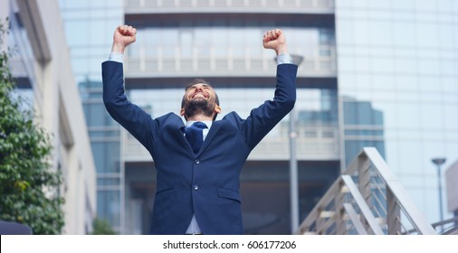 A businessman dancing in the square and is glad to have received a promotion or winning a bet. Concept: finance, business, elation, victory, wager, career, dance	 - Shutterstock ID 606177206
