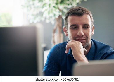 Businessman Deep In Thought Working On A Laptop