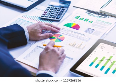Businessman is deeply reviewing a financial report for a return on investment or investment risk analysis. - Shutterstock ID 1167269236