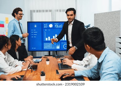 Businessman deliver business presentation with financial report data analysis or market trend show on big TV screen for strategic planing in meeting room for company future direction. Habiliment - Shutterstock ID 2319002109