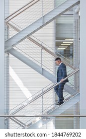 Businessman descending stairs in an office - Shutterstock ID 1844769202
