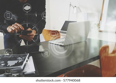 Businessman Or Designer Using Smart Phone With Laptop And Digital Tablet Computer And Document On Desk In Modern Office With Virtual Interface Graphic Icons Network Diagram