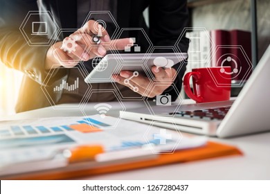 businessman or Designer using tablet with laptop and document on desk in modern office with virtual interface graphic icons network diagram. - Shutterstock ID 1267280437