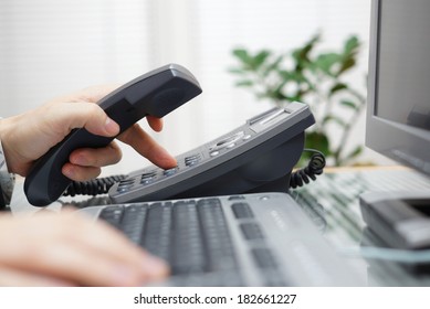businessman is dialing a phone number in office