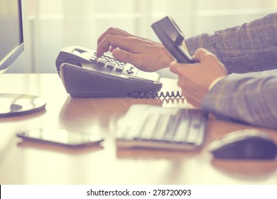 Businessman Dialing Voip Phone With Pale Vintage Color Effect