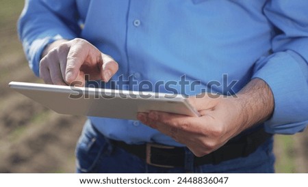 Businessman digital agricultural farmer with tablet. Hands male professional using tablet. Creation planting plans harvest schedules labor allocation aspects of agricultural business farm management.