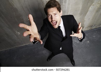 Businessman Disappointedly Reaching Up, Portrait