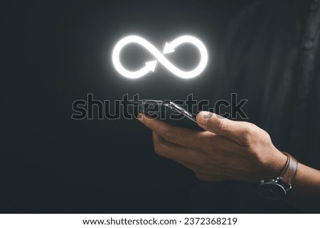 Businessman displays smartphone with infinity symbol, indicating unlimited connection in data technology. Cyber space, future unlimited. Infinite, internet information. technology infinity data