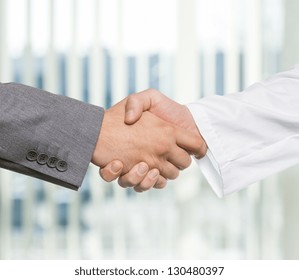 Businessman And Doctor Shaking Hand's In Office. Business Concept