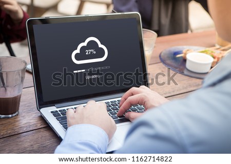 Businessman doing cloud uploading using laptop / computer concept at the outdoor cafe
