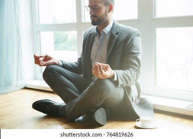 businessman doing yoga in lotus pose