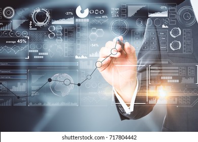 Businessman drawing abstract business chart hologram on blurry office interior background. Network concept. Double exposure 