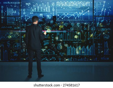 Businessman Drawing Business Statistics On Glass Wall