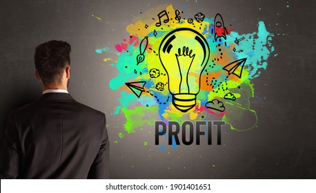 businessman drawing colorful light bulb with PROFIT inscription on textured concrete wall, new business idea concept