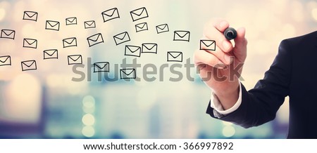 Businessman drawing E-mails concept on blurred abstract background 
