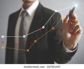 Businessman drawing graphics a growing graph