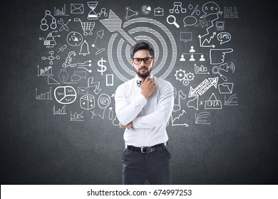 Businessman drawing icons on blackboard