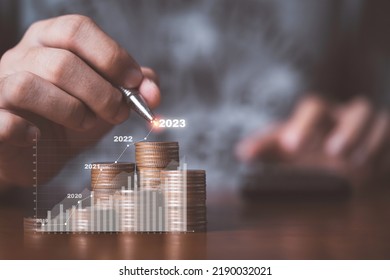 Businessman drawing increasing graph with coin stacking for increase financial interest rate and business investment growth from dividend concept. - Shutterstock ID 2190032021